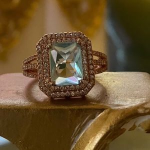 Light blue gemstone, withwhite accent. Rose gold.